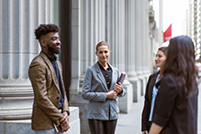 Young business professionals talking outside.